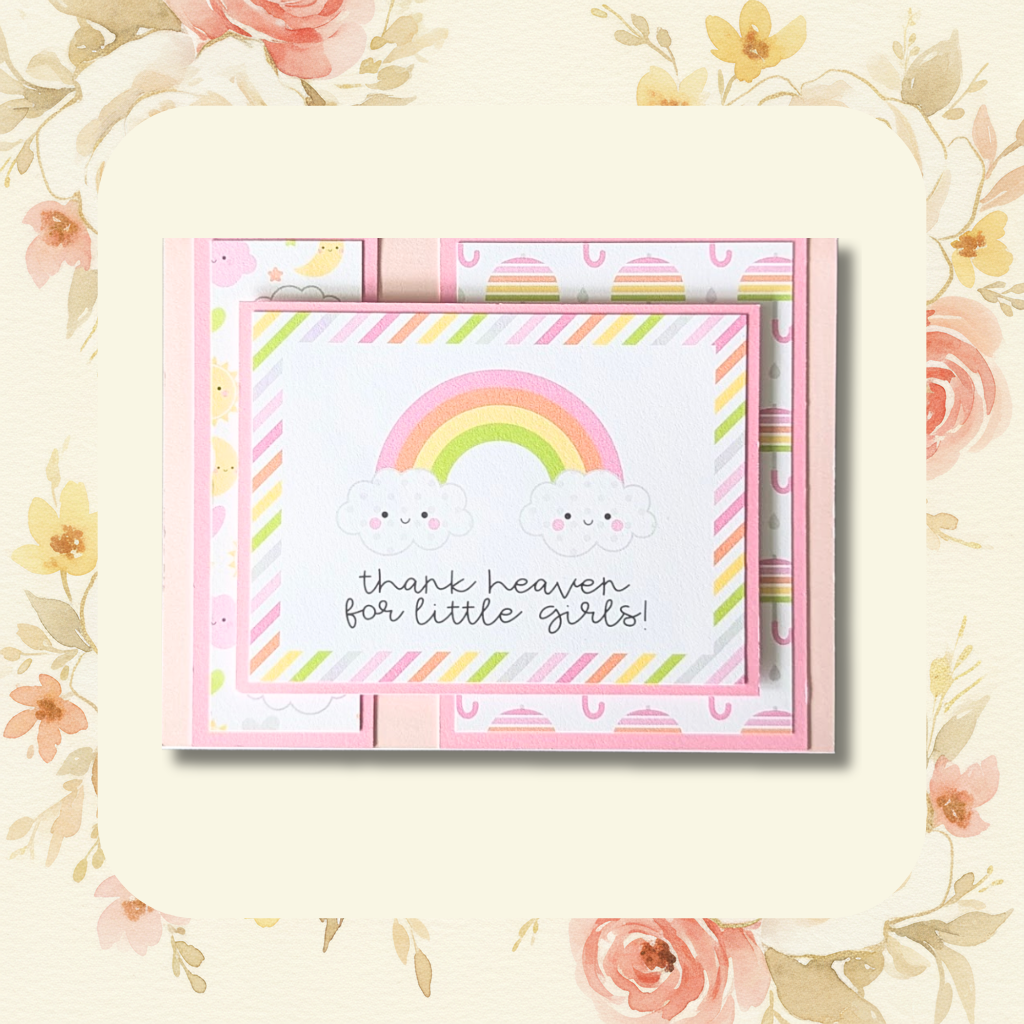 Handmade thank heaven for little girls new baby greeting card with rainbow, smiling clouds and pink patterned papers on blush floral background