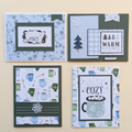 Four cosy cocoa and winter wishes Christmas greeting cards arranged on a cream background