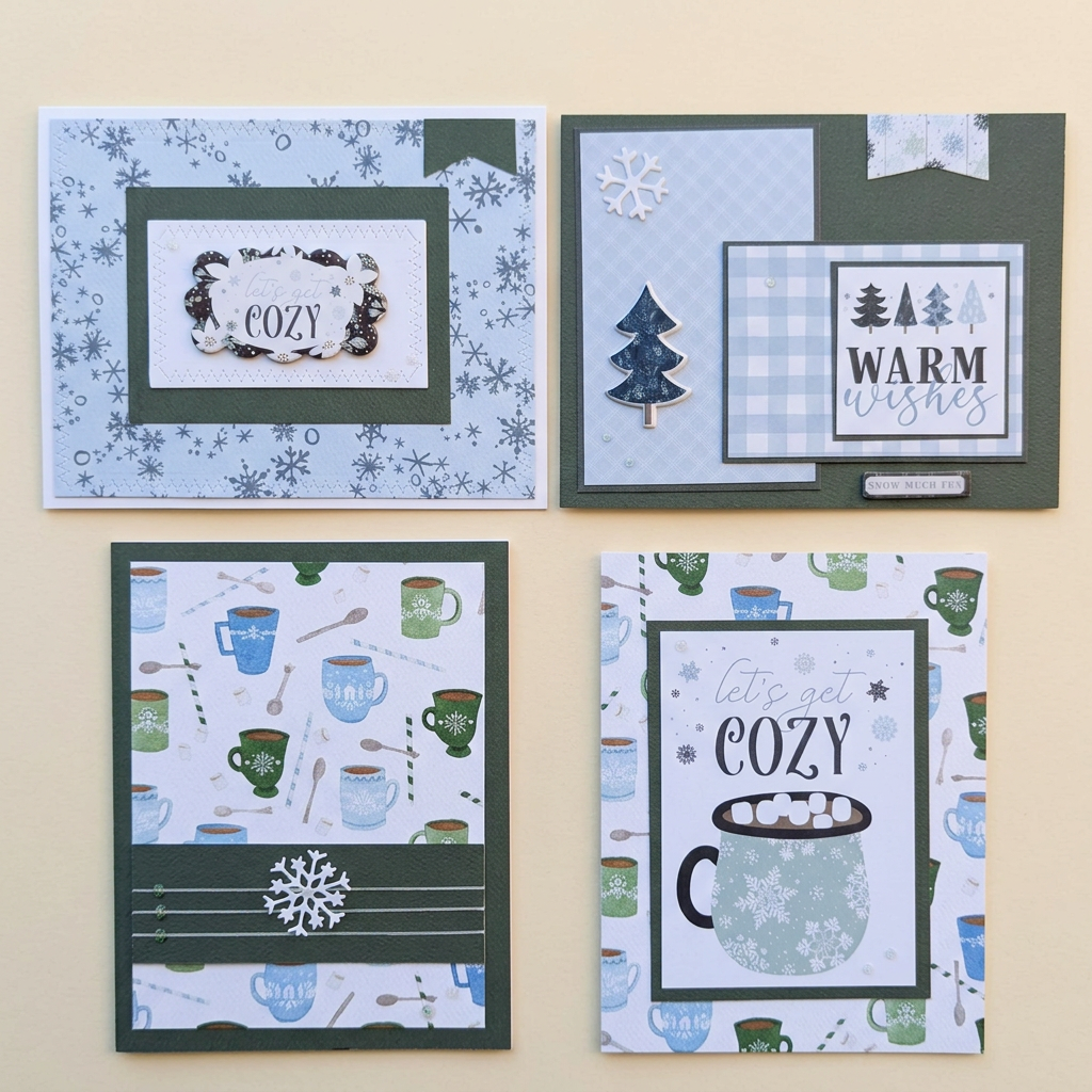 Four cosy cocoa and winter wishes Christmas greeting cards arranged on a cream background